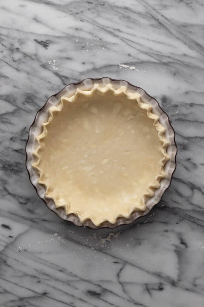Bottom all-butter pie crust fitted into a pie dish with crimped edges.