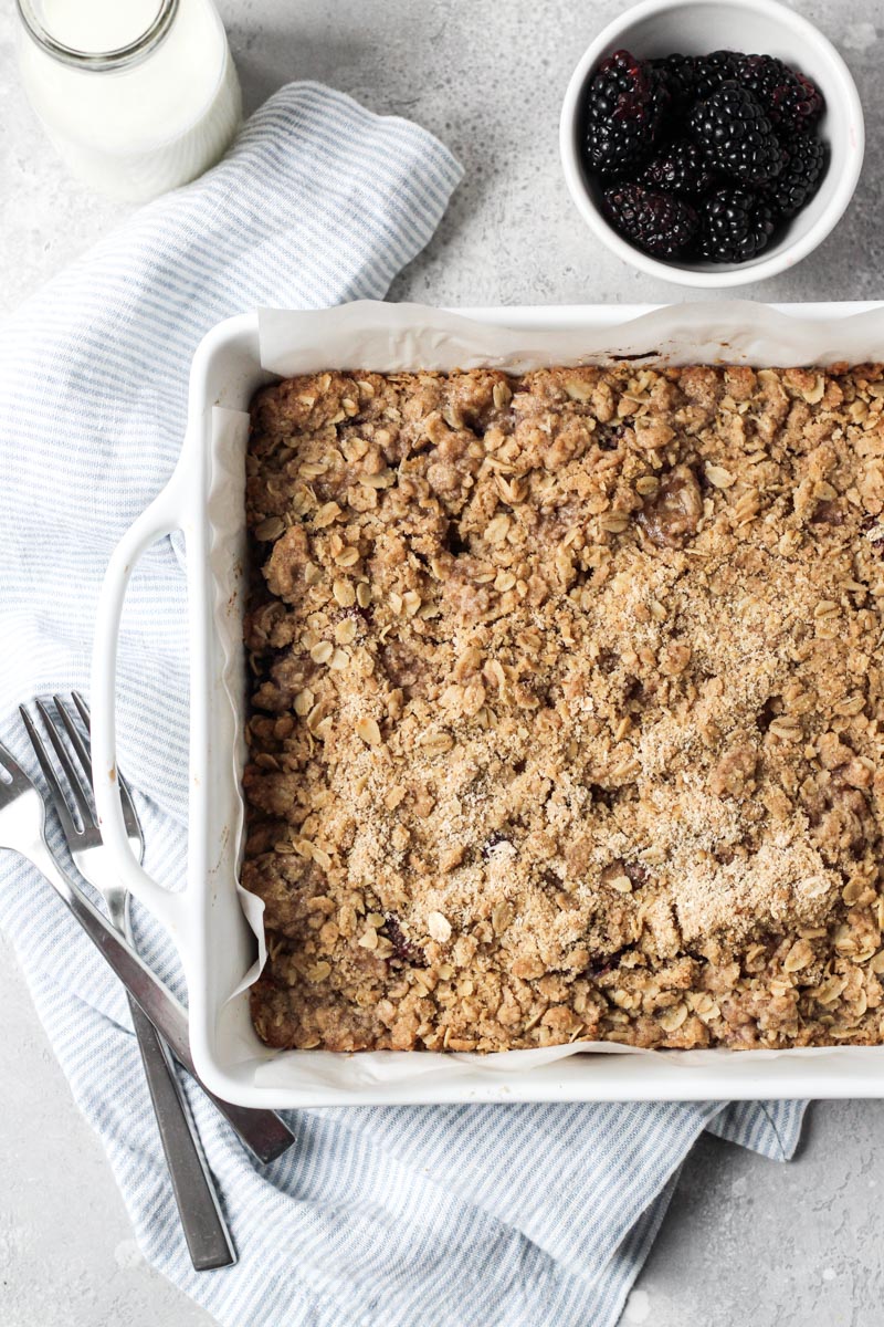 Baking dish with blackberry bars with an oat crumble topping.