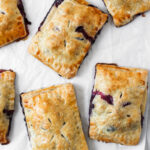 Blueberry hand pies arranged on parchment paper.
