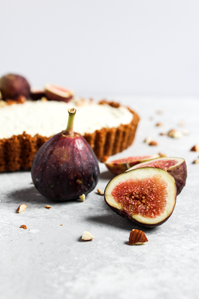 Fresh fig slices with a no-bake honey mascarpone fig tart in the background.