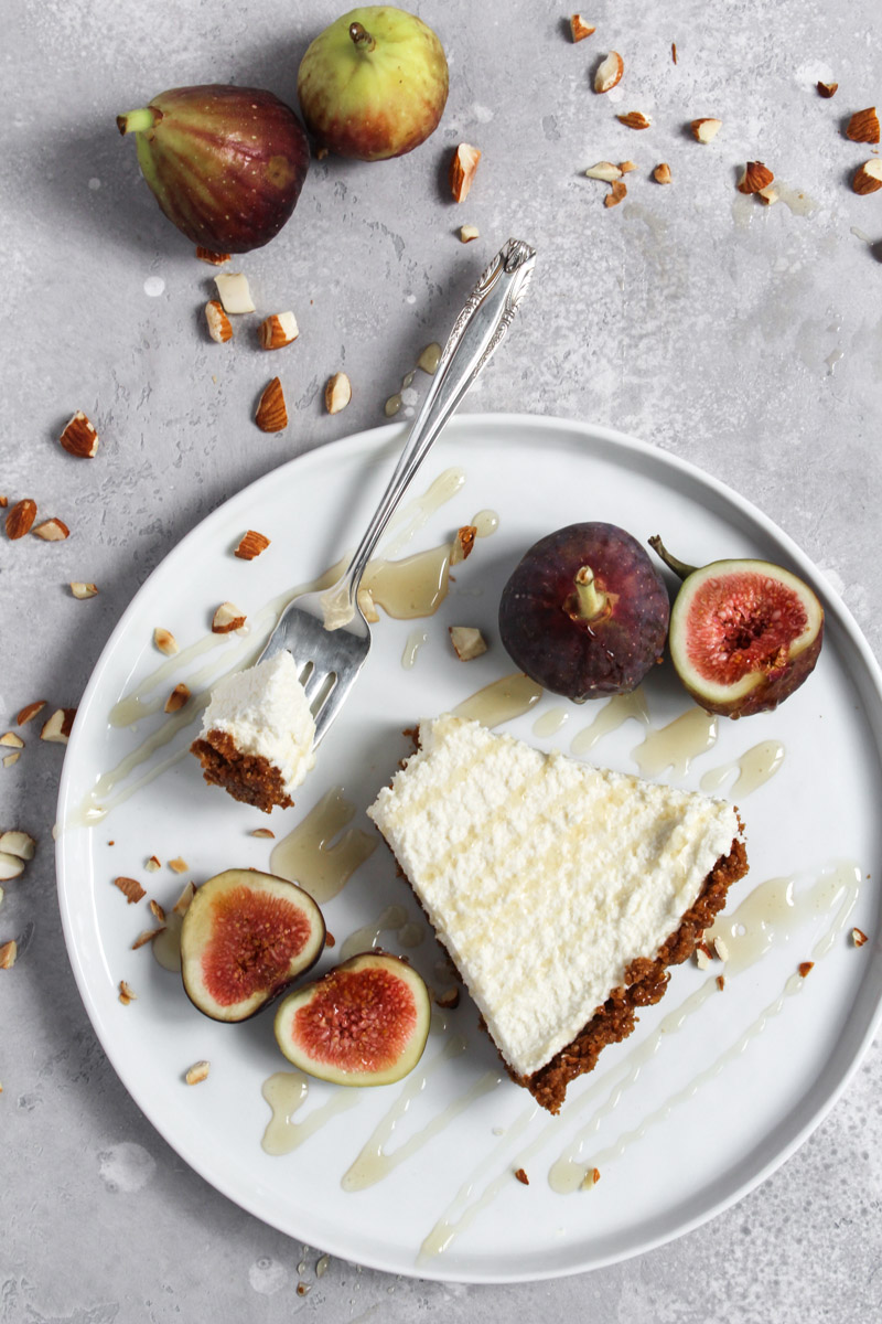 Slice of no-bake honey mascarpone fig tart on a plate with fresh figs for garnish.