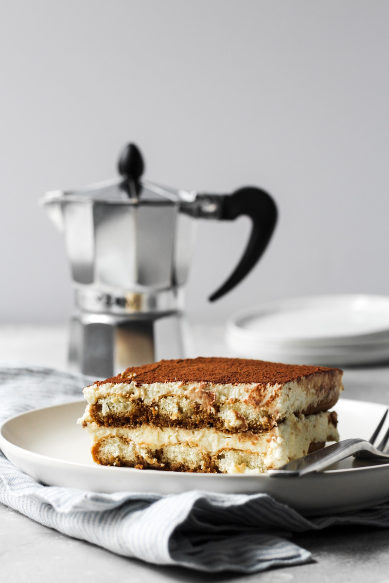 Slice of tiramisu with espresso pot