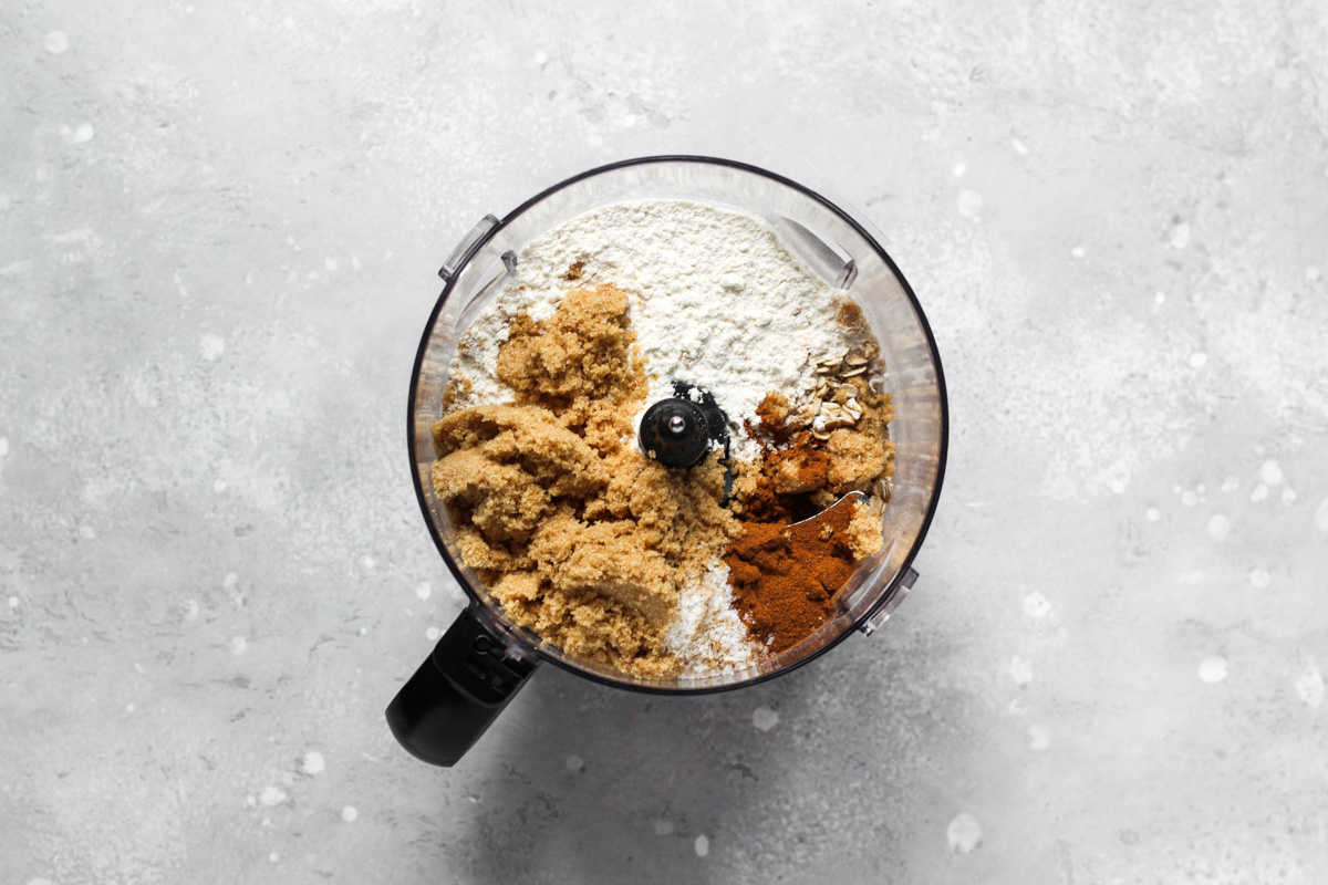 Food processor bowl with crumble topping ingredients.
