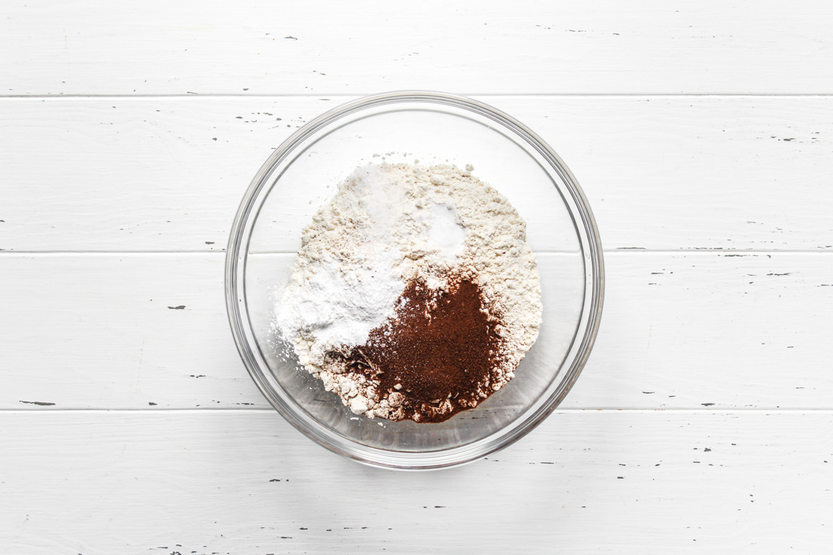 Dry ingredients in a glass mixing bowl for coffee cupcake batter.