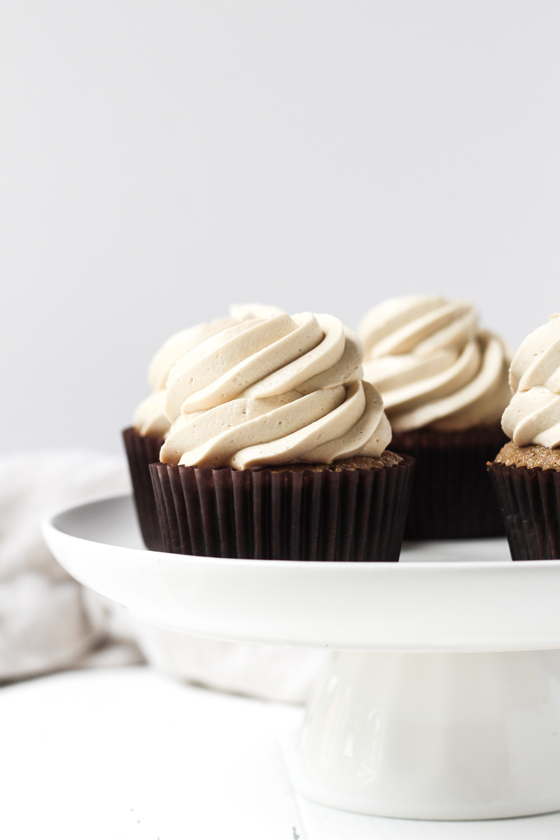 Coffee cupcakes with coffee buttercream on a cake stand.