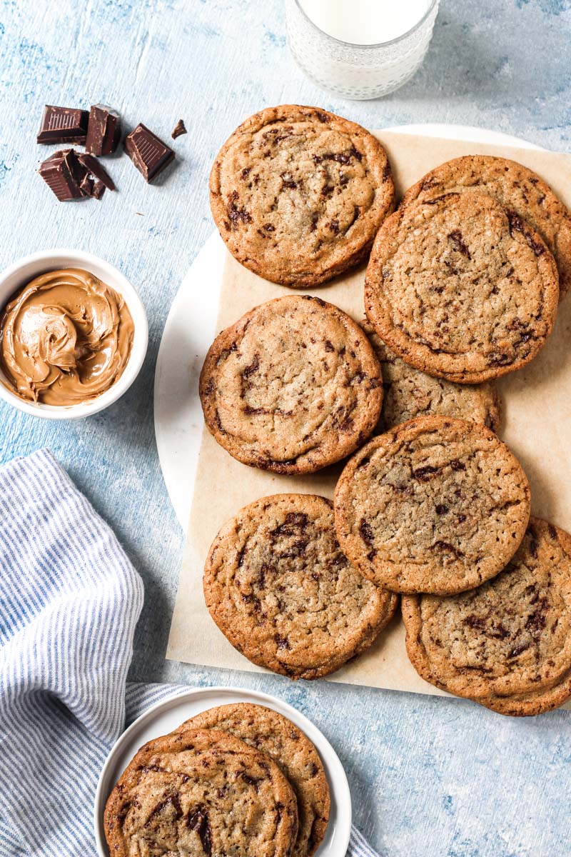 Overhead shot of cookie butter cookies on parchment paper and bowl of cookie butter.