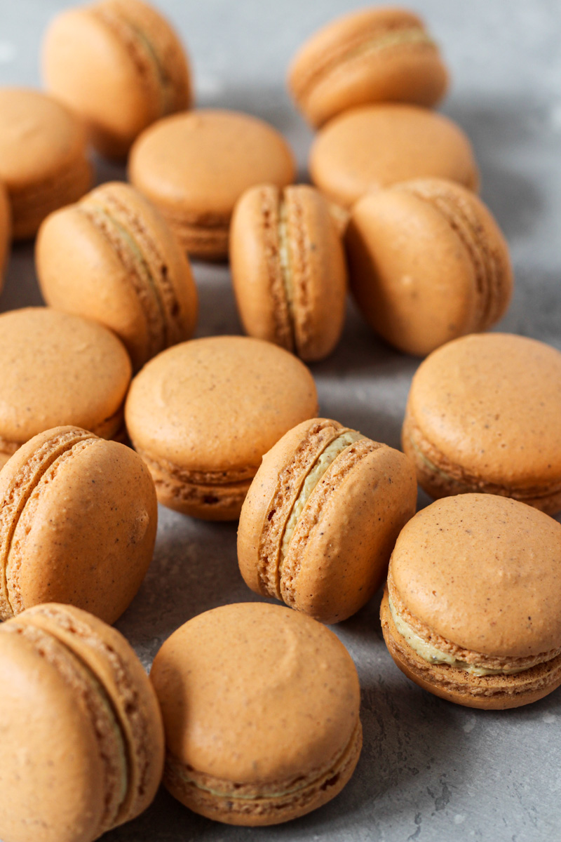 Spread of pumpkin macarons filled with pumpkin Swiss meringue buttercream.