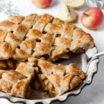Chai apple pie with a lattice crust and half the pie sliced.