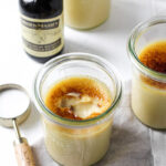 Jars of maple creme brulee with one displaying a cracked topped.