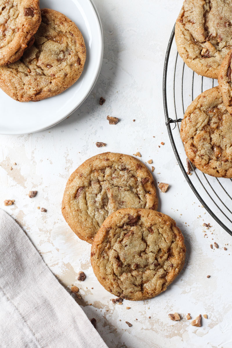 Overhead shot of two brown butter cookies with bits of toffee.