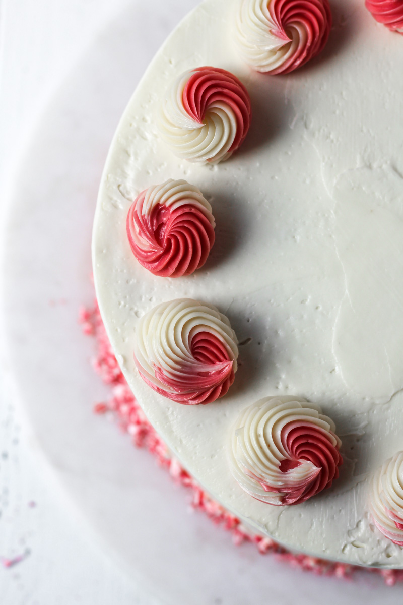 Overhead of peppermint flavored cake with swiss meringue buttercream and swirls for red and white frosting.