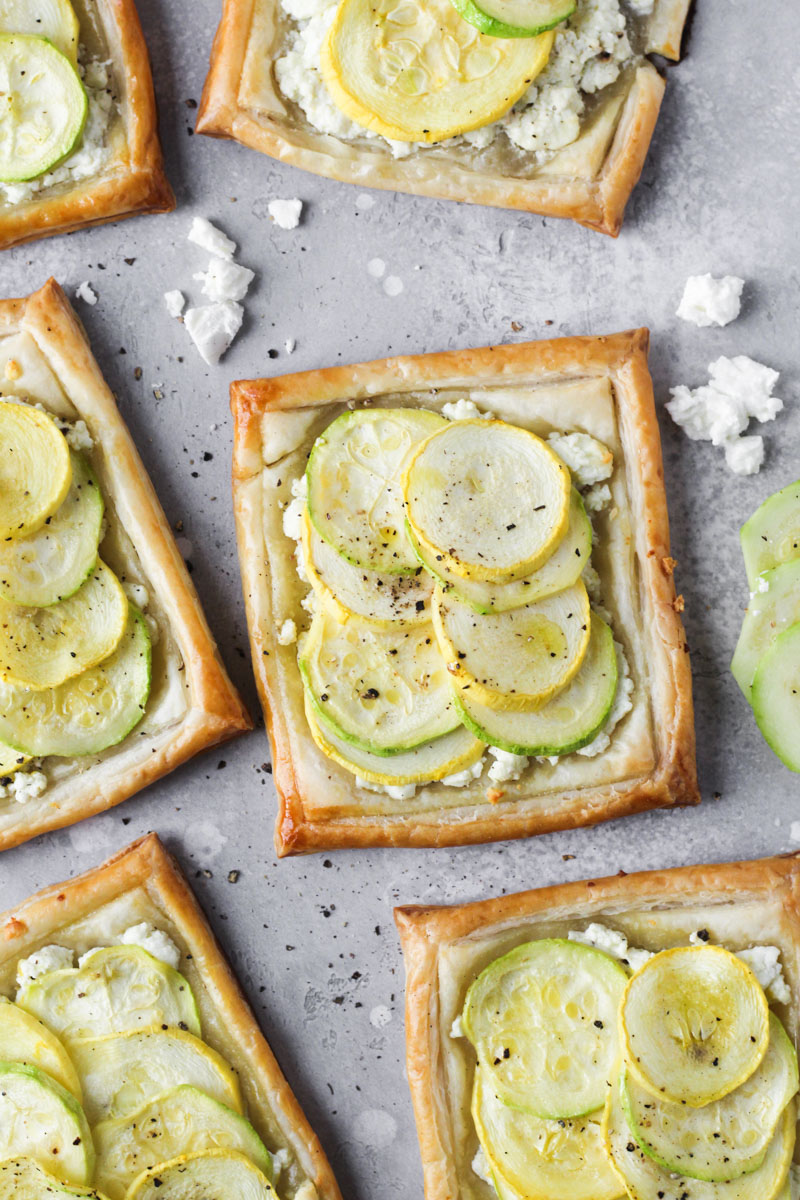 Individual baked puff pastry with feta, zucchini and yellow squash tarts.