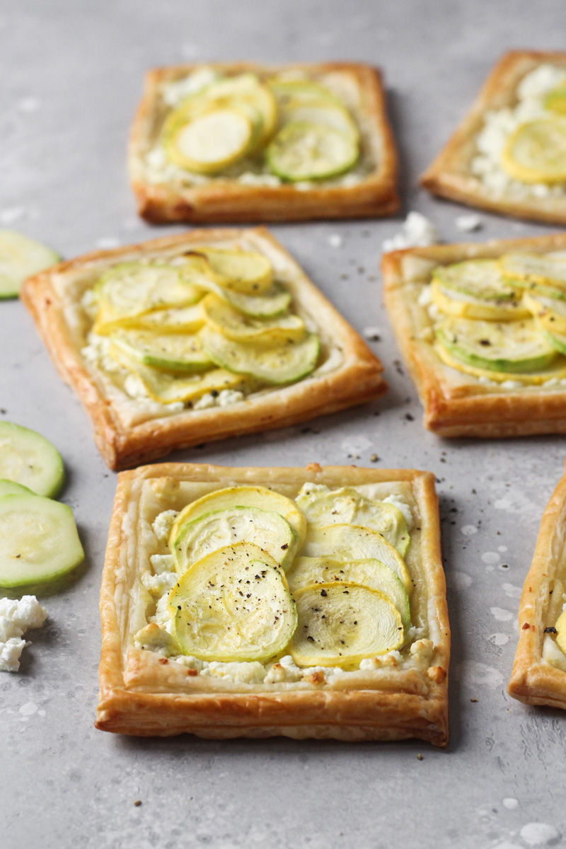 Individual baked puff pastry with feta, zucchini and yellow squash tarts.