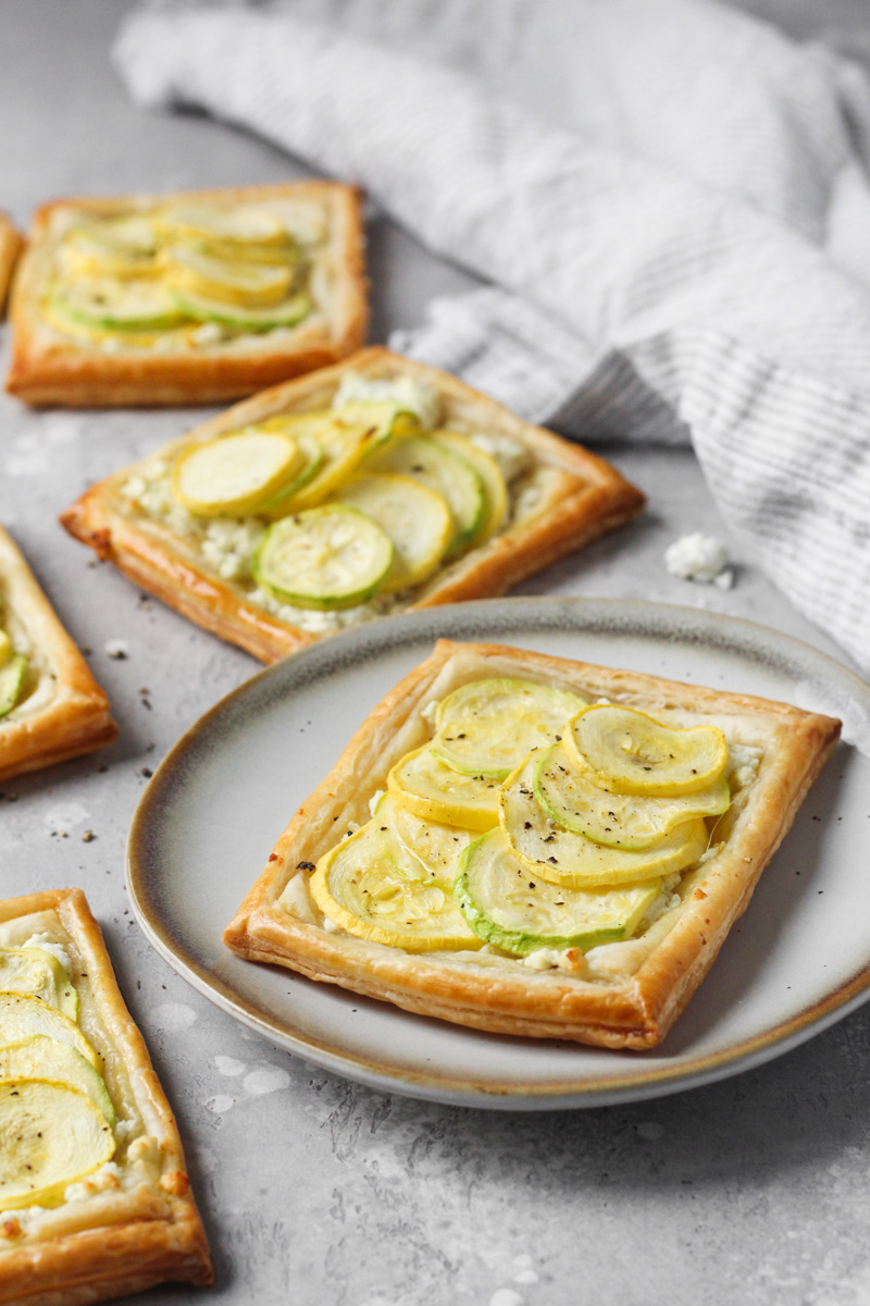Individual baked puff pastry with feta, zucchini and yellow squash tarts.