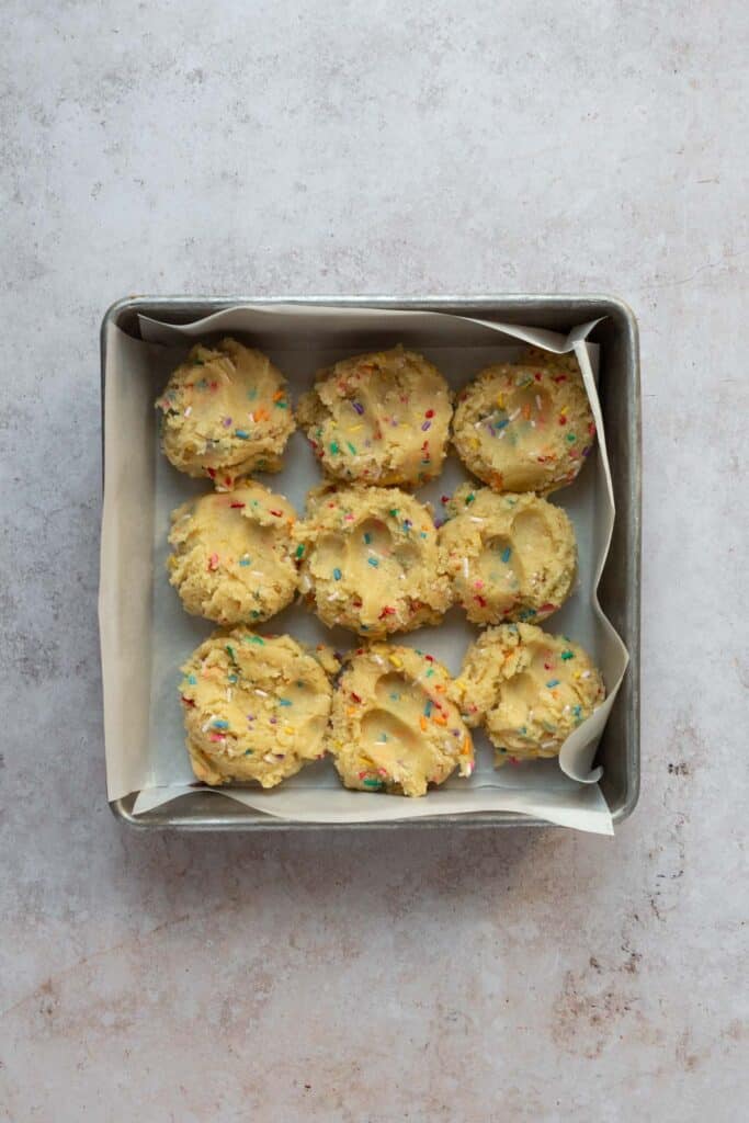 Baking pan with scoops of cookie dough.
