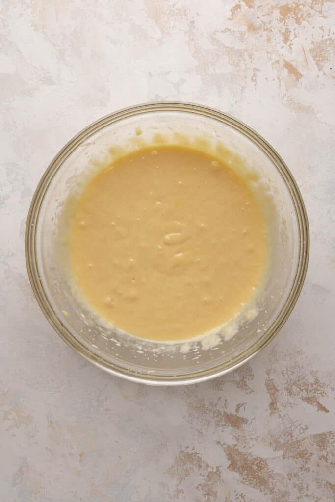 Creamed sugar, butter and oil mixed with eggs and vanilla in a mixing bowl for 8 inch cake.