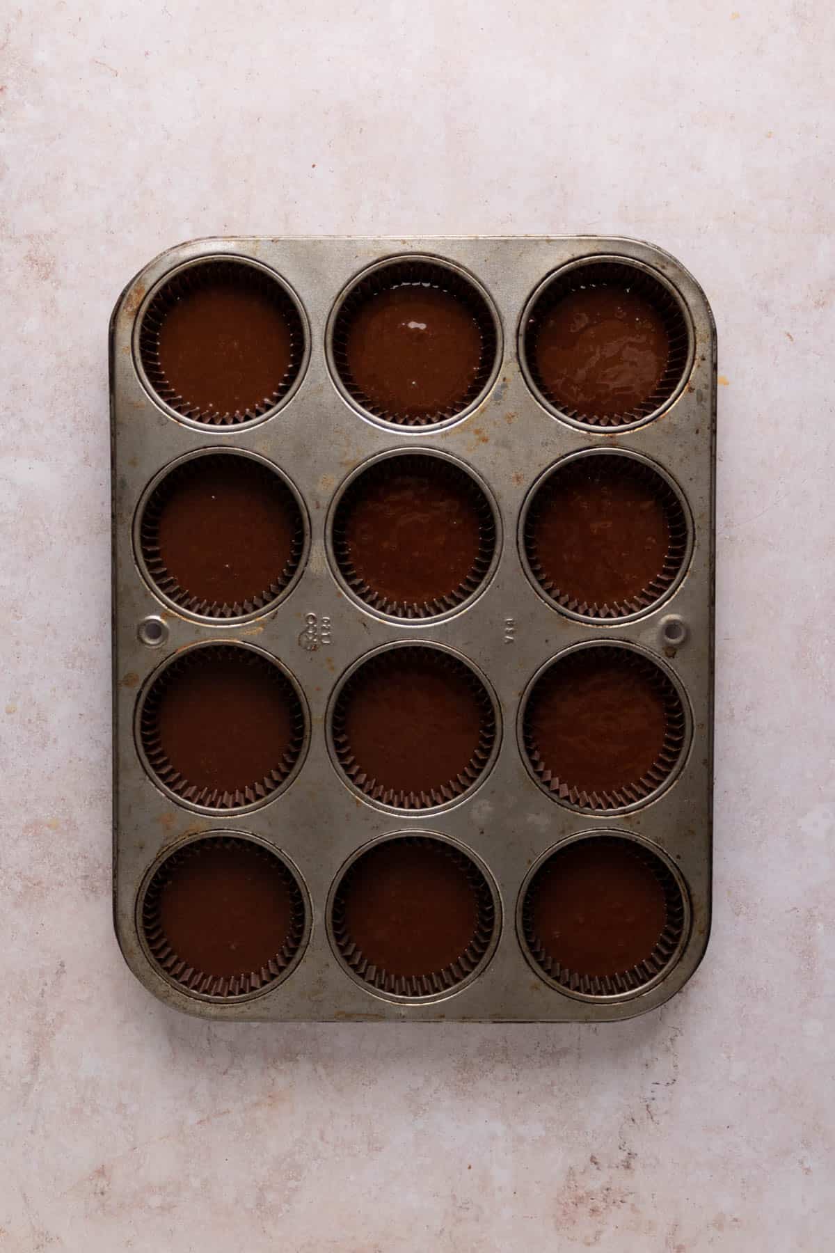 Chocolate cupcake batter in muffin tins.