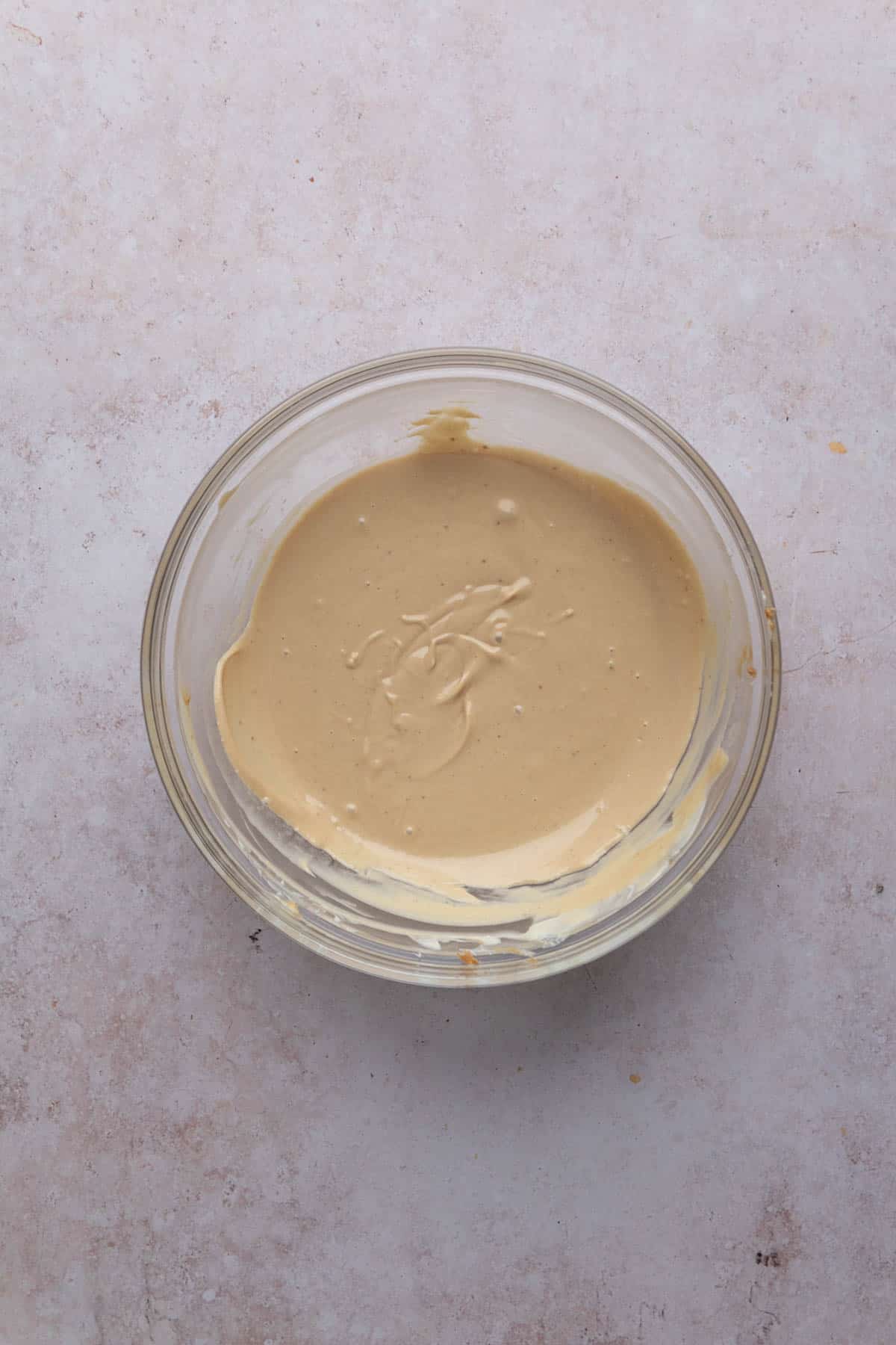 White chocolate melted with biscoff spread in a mixing bowl.
