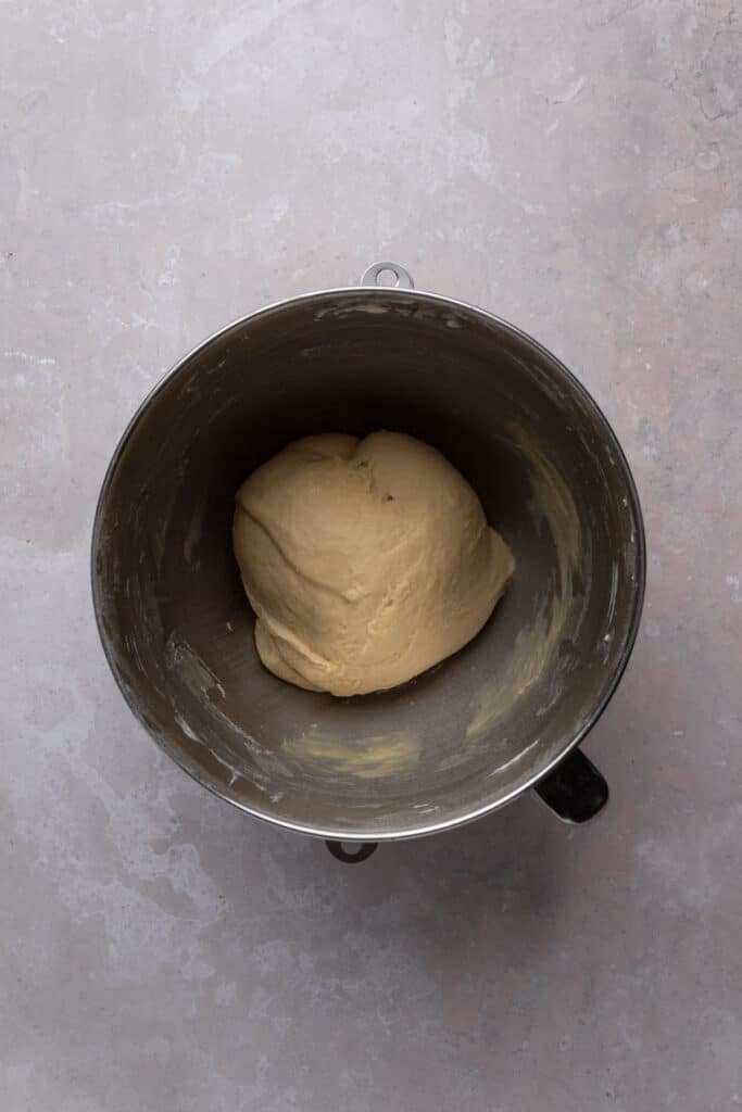 Brioche dough in a mixer bowl mixed and ready for proofing.