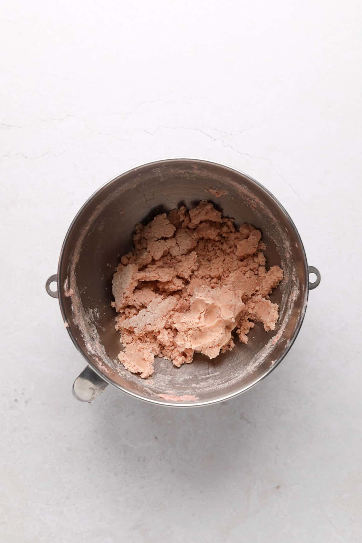 Stand mixer bowl with strawberry shortbread cookie dough.