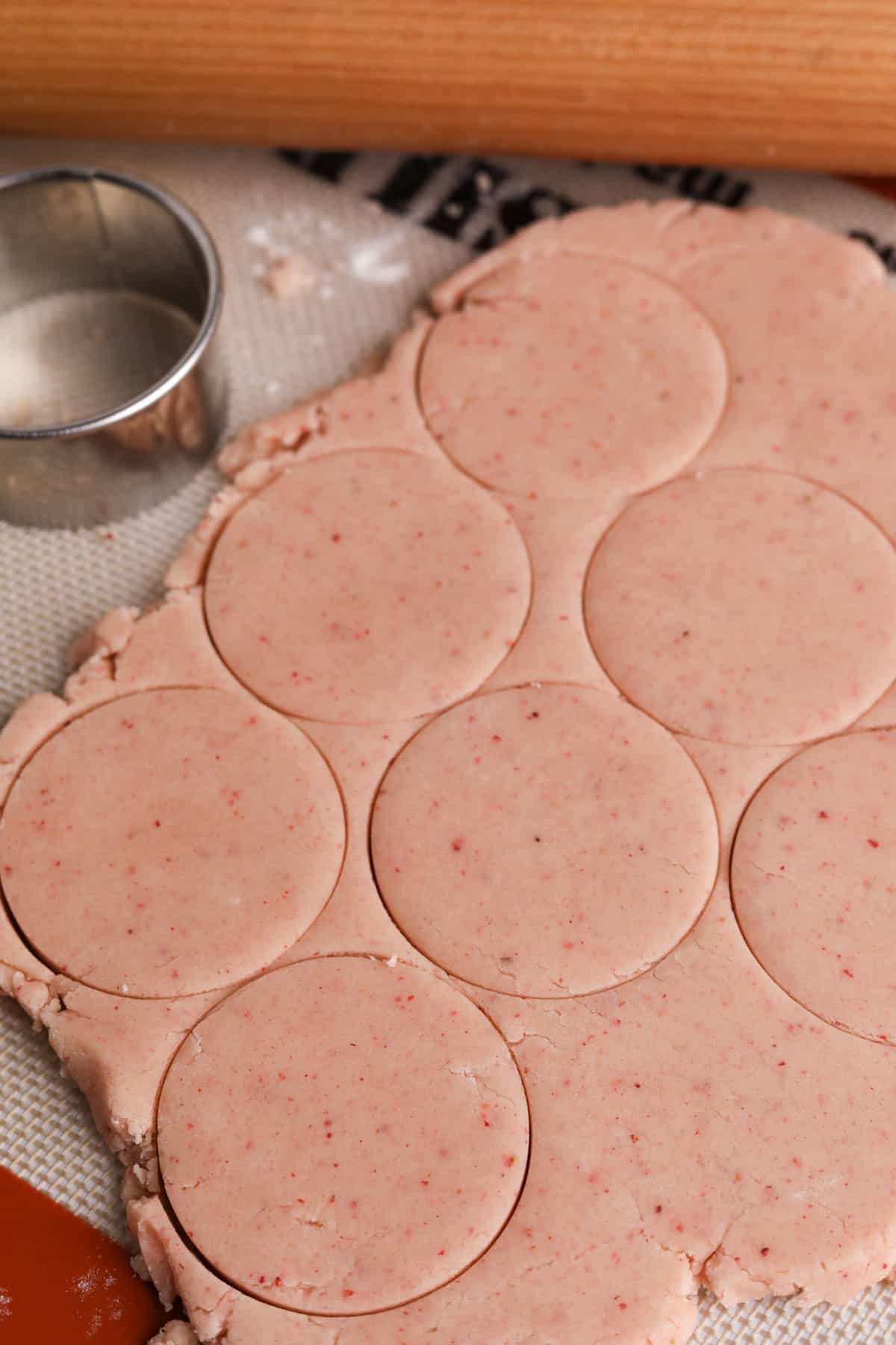 Strawberry shortbread cookie dough rolled and cut with round cookie cutter.