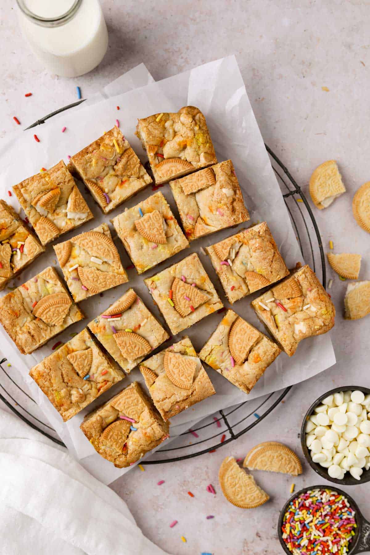 Overhead shot of squares of birthday cake blondies with white chocolate chips and rainbow sprinkles.