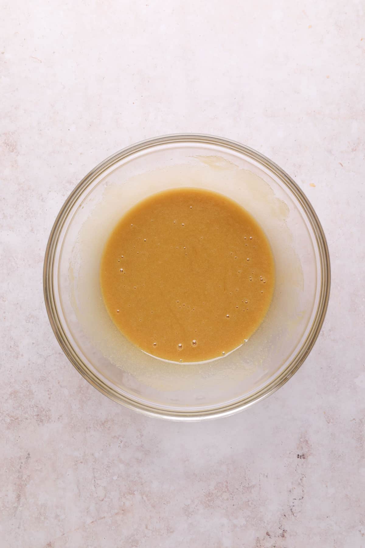 Whisked melted butter, eggs, and granulated sugar in a mixing bowl.