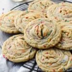 Stack of funfetti stuffed cookies with buttercream on a French wire rack.