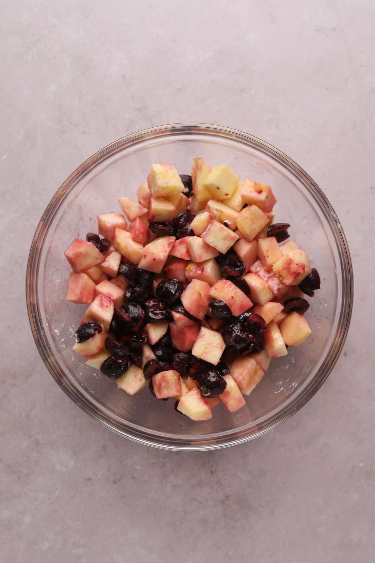 Mixed cherry apple filling in a large mixing bowl for cherry apple crumble.