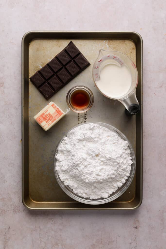 Chocolate fudge frosting ingredients on a baking sheet.