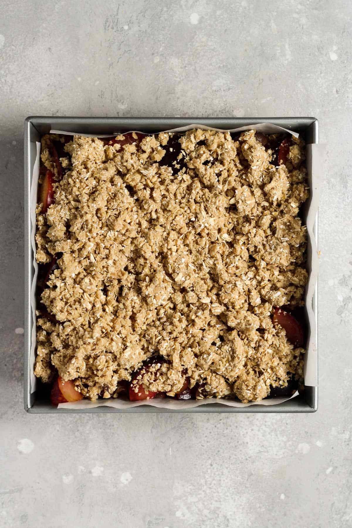 Unbaked plum bars in a 9x9 square baking pan.