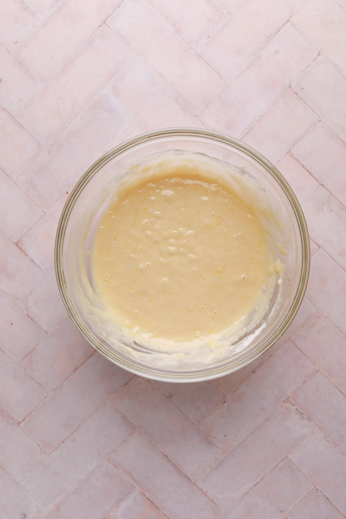 Lemon cake batter mixed in a glass bowl.