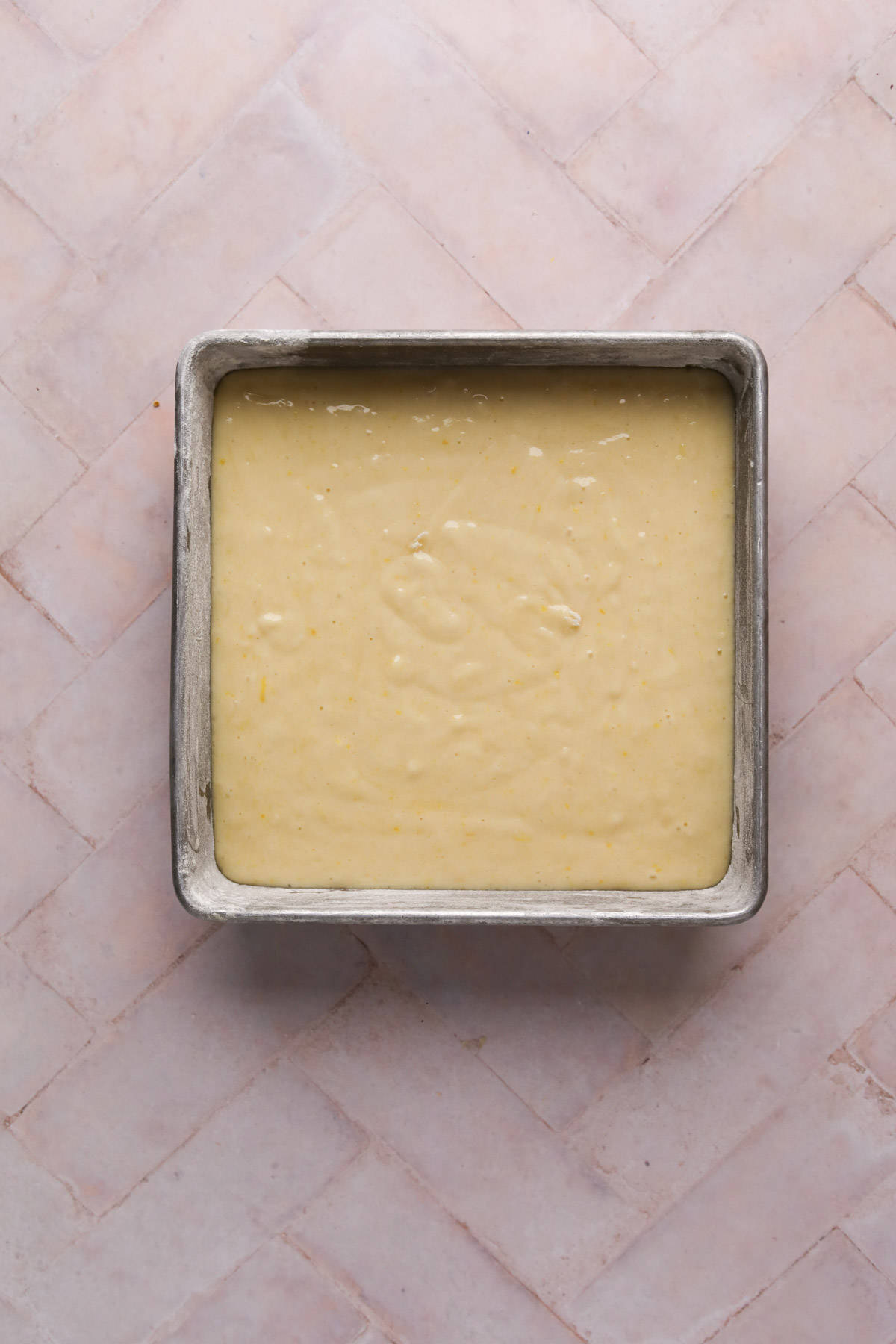 Lemon cake batter in a greased and flour 8x8 square cake pan.