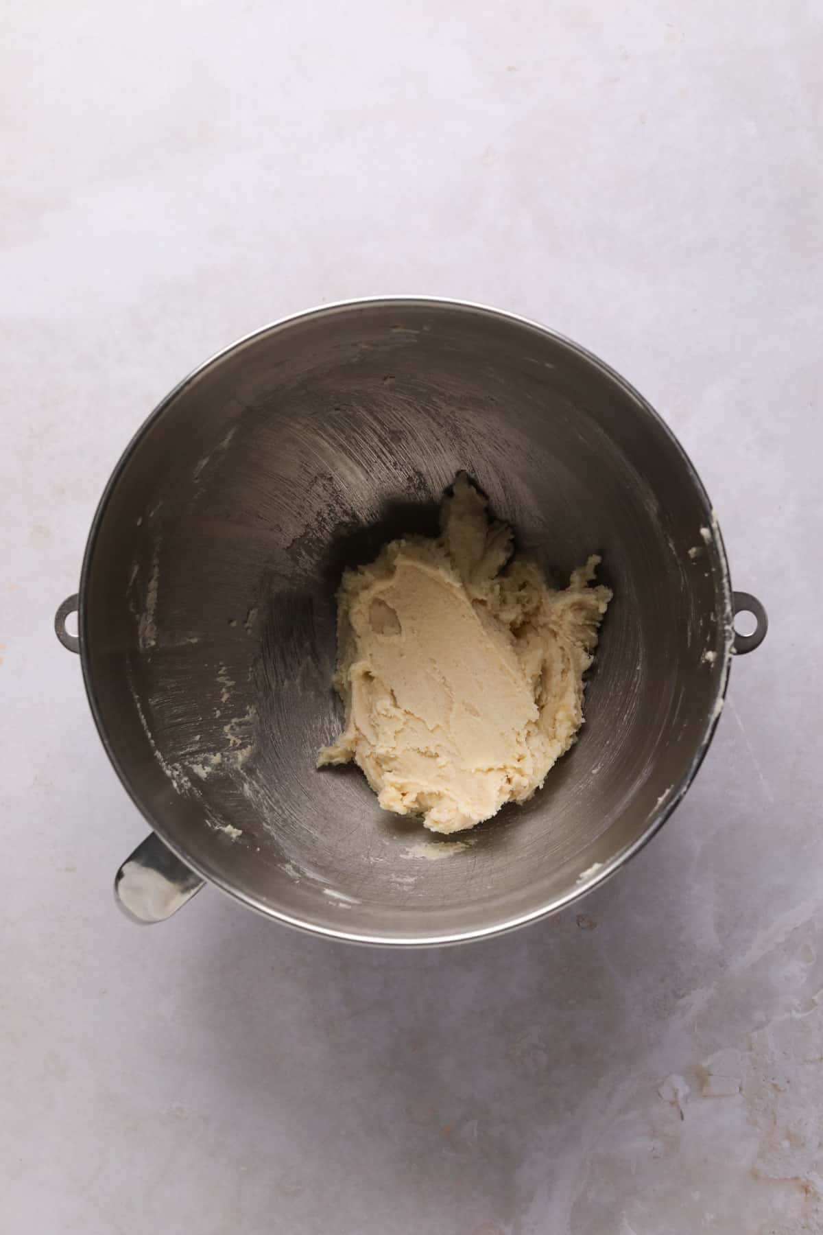 Creamed butter and sugar in a stand mixer mixing bowl for funfetti cookies.