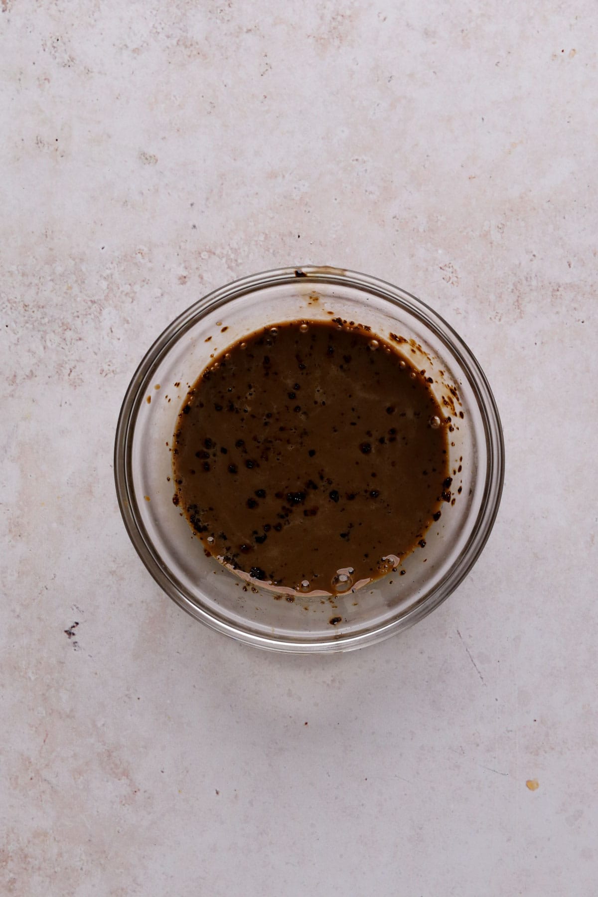 Instant coffee dissolved in cream in a small glass bowl.