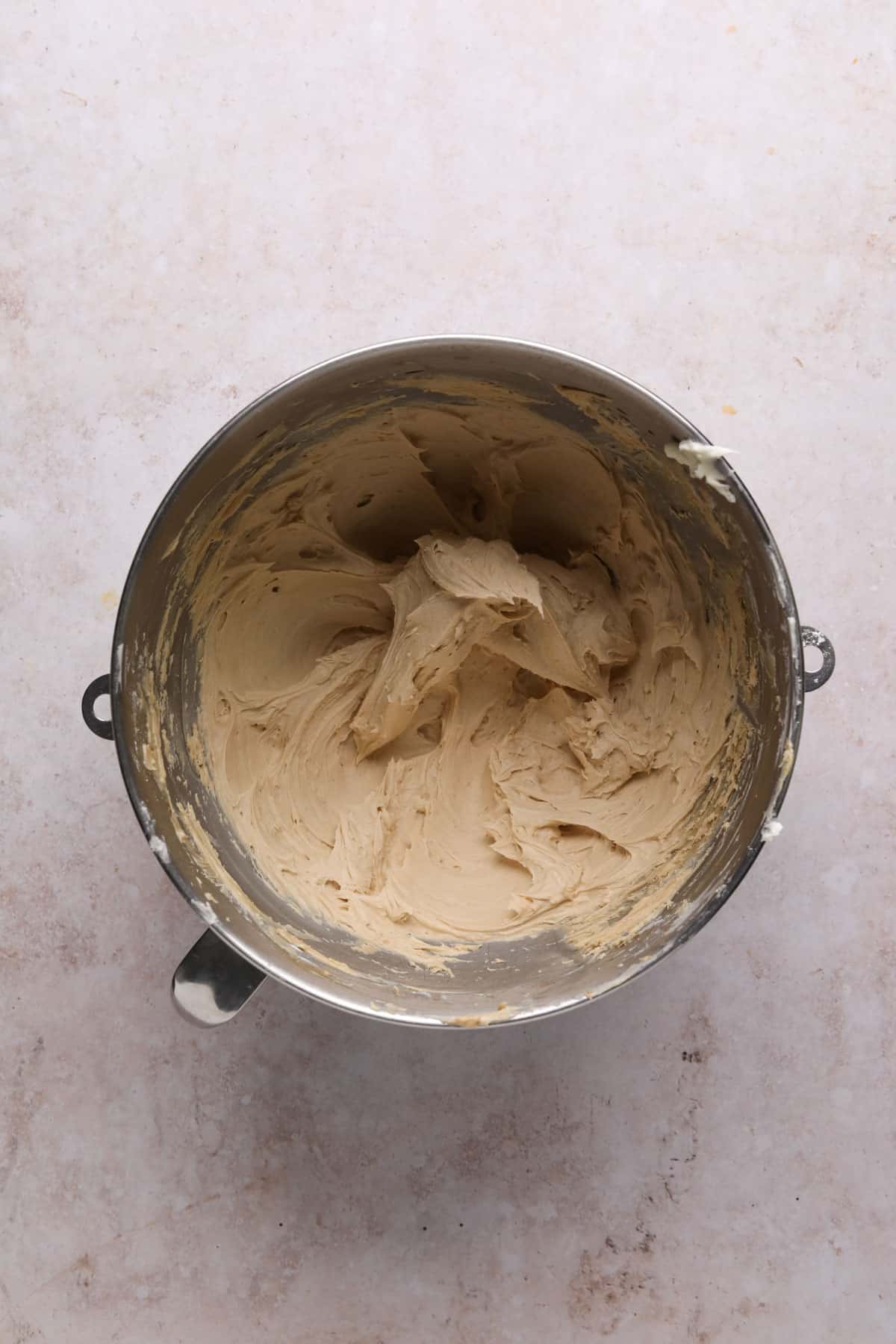 Coffee buttercream mixed in a stand mixer bowl.