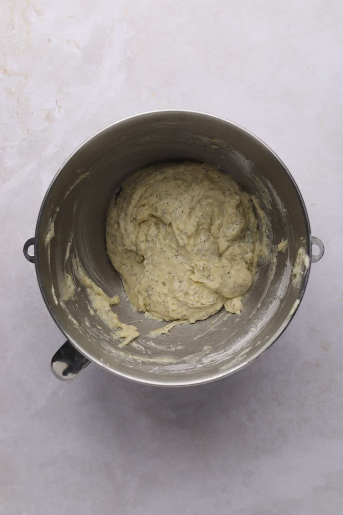Lemon poppy seed cupcake batter mixed in a metal stand mixer bowl.