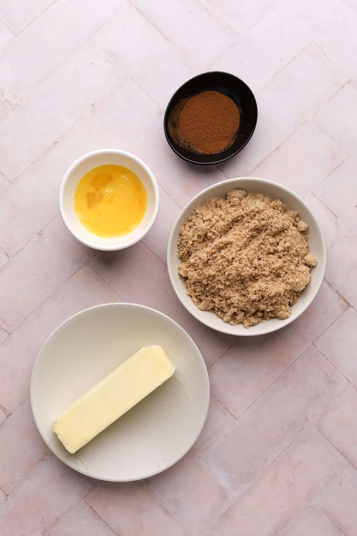 Filling ingredients for homemade cinnamon rolls in bowls on a flat surface.
