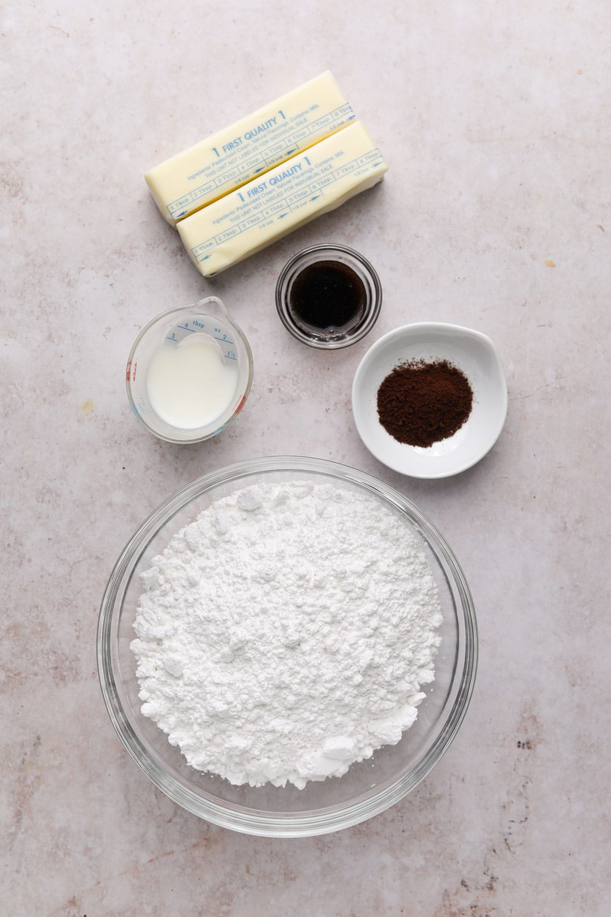 Ingredients for vanilla bean espresso buttercream in bowls on a flat surface.