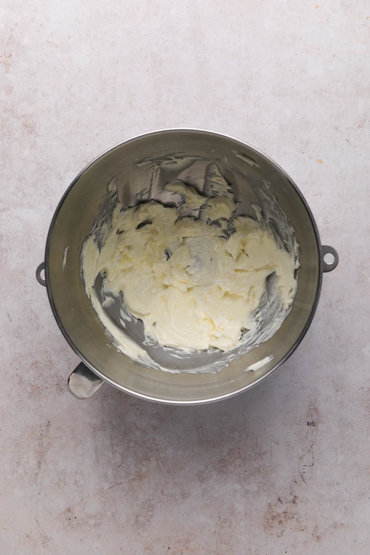 Creamed butter in a metal stand mixer bowl.