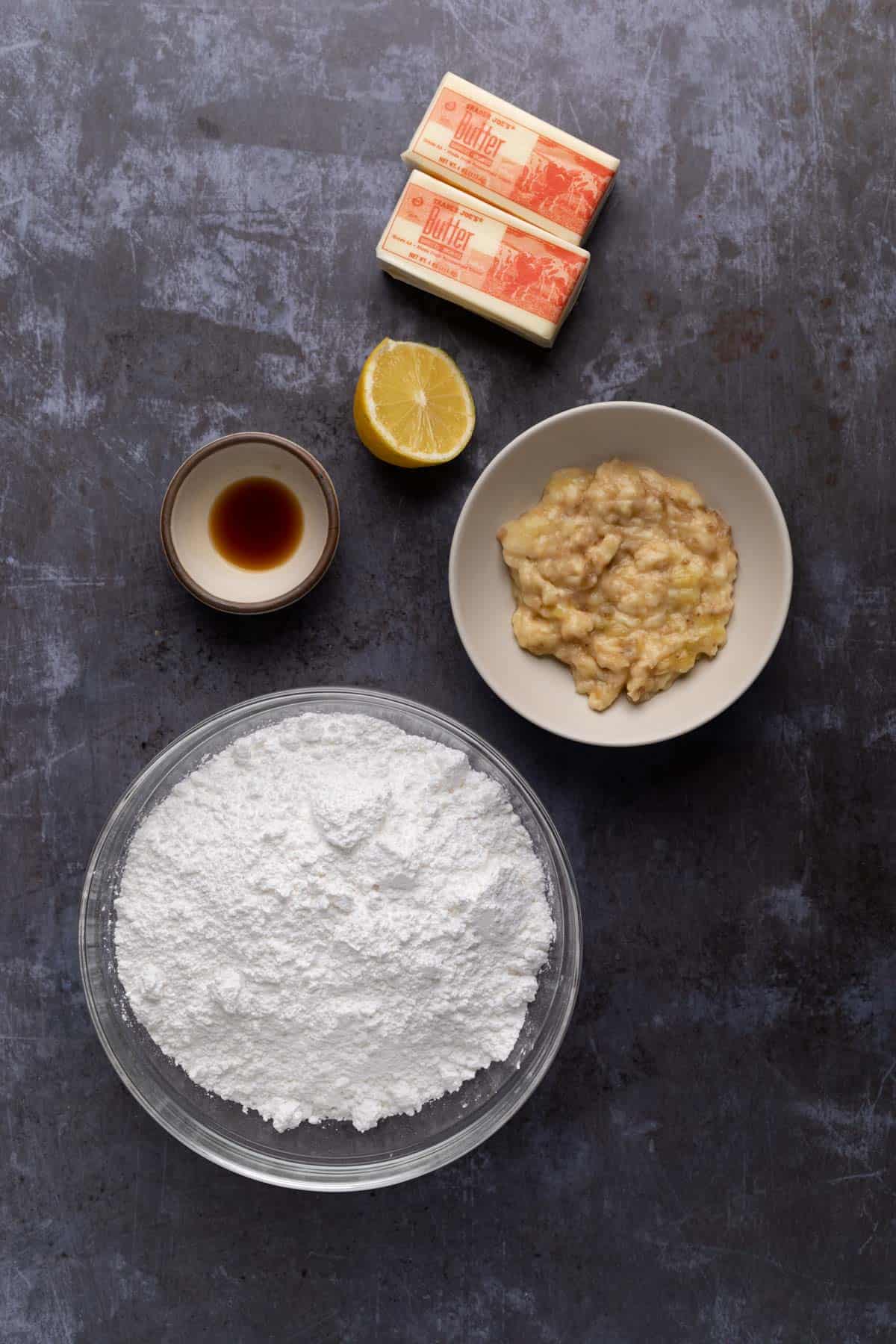 Ingredients for banana buttercream frosting in bowls on a flat surface.