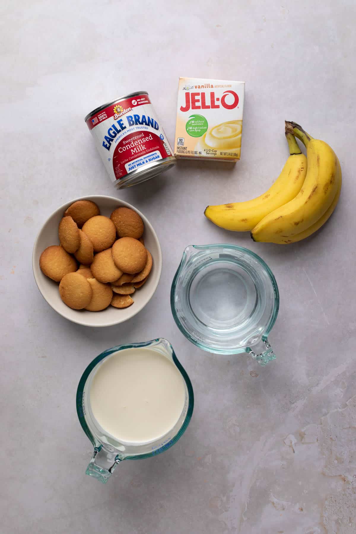 Ingredients for banana pudding in a jar on a flat surface.