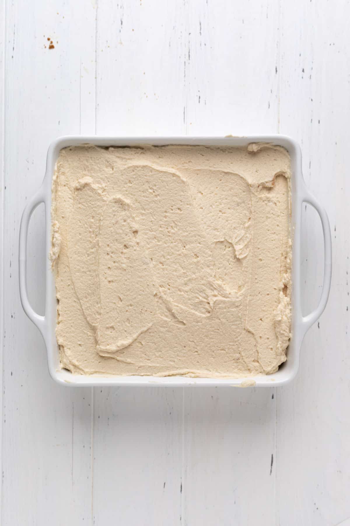 Layered Biscoff tiramisu in a white square ceramic baking dish on a flat surface.