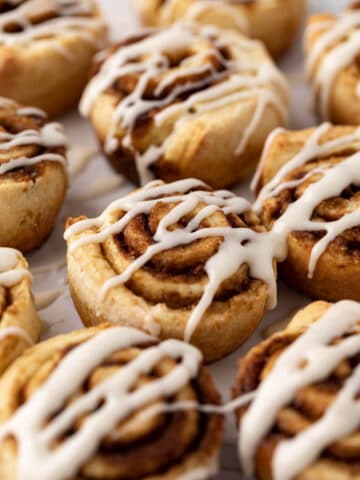 Close up of no yeast cinnamon roll muffins drizzle with a simple vanilla glaze.