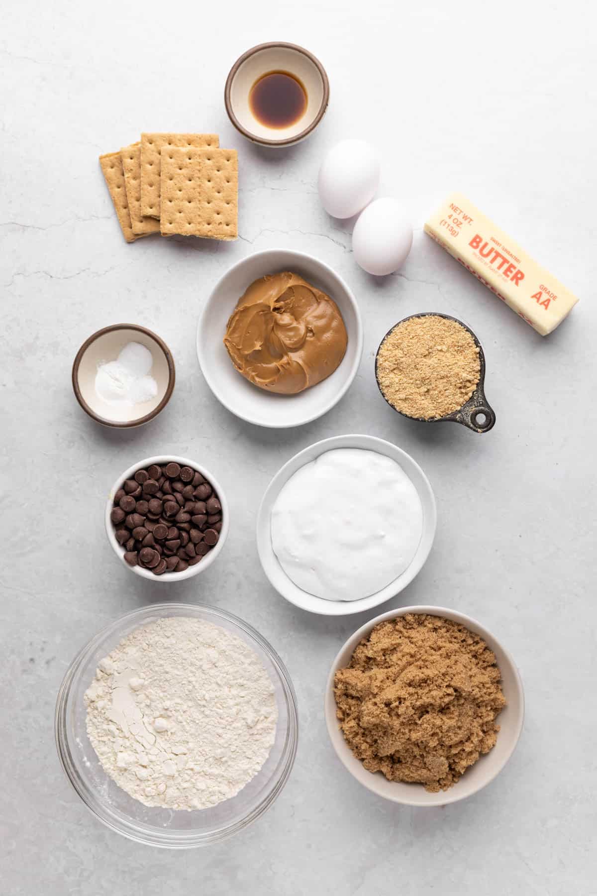 Ingredients for s'mores blondies in bowls set o a flat surface.