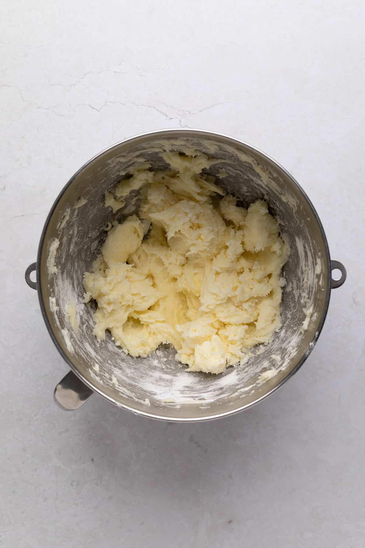 Butter, cream cheese, powdered sugar and orange zest mixed in a stand mixer metal bowl.