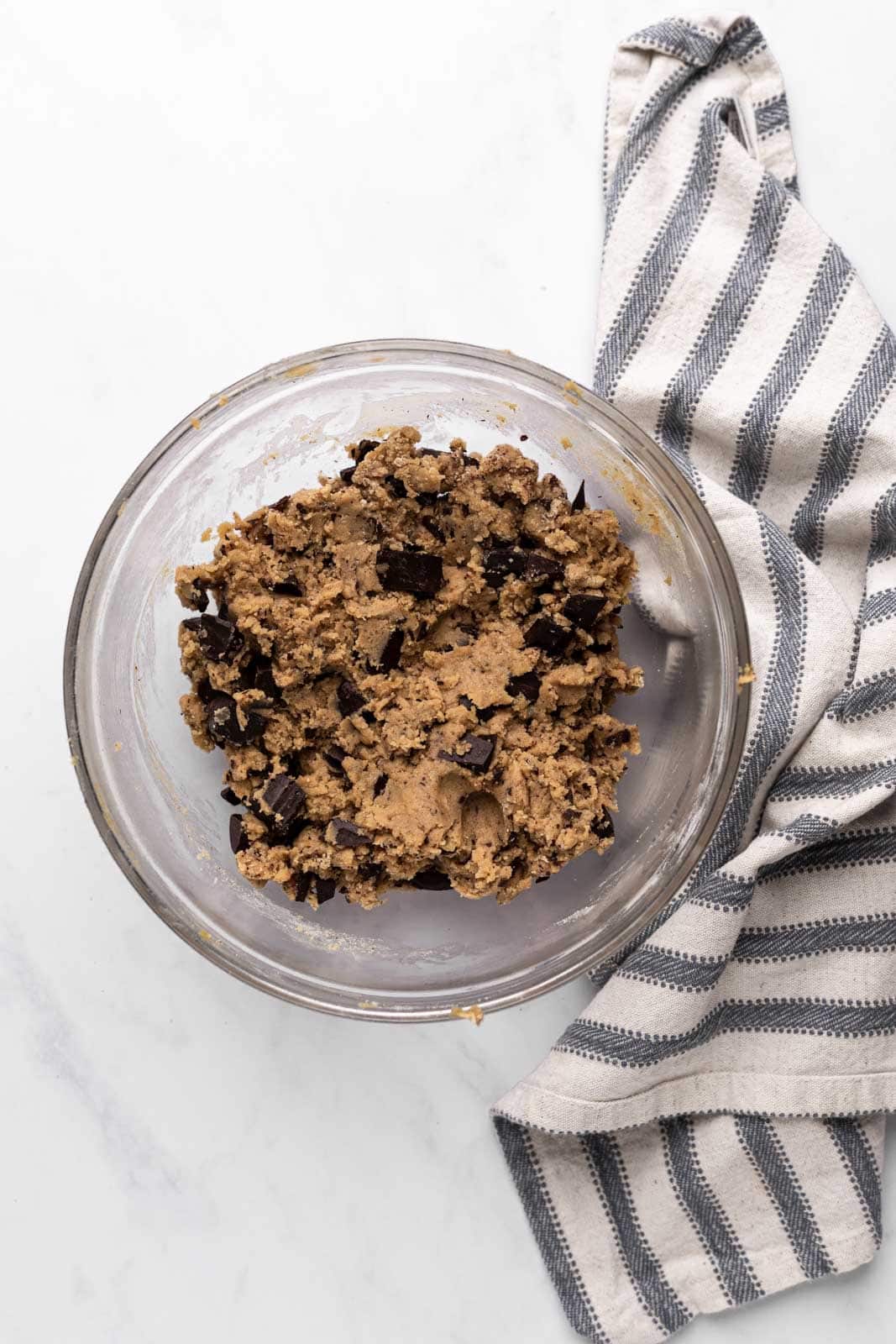 Brown butter chocolate chip cookie dough mixed in a glass mixing bowl set on a flat surface.