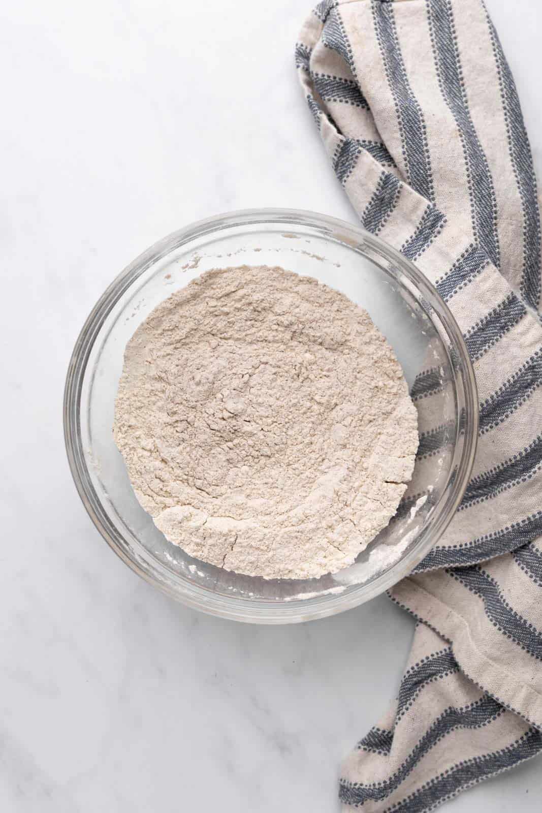 Whisked dry ingredients in a glass mixing bowl.