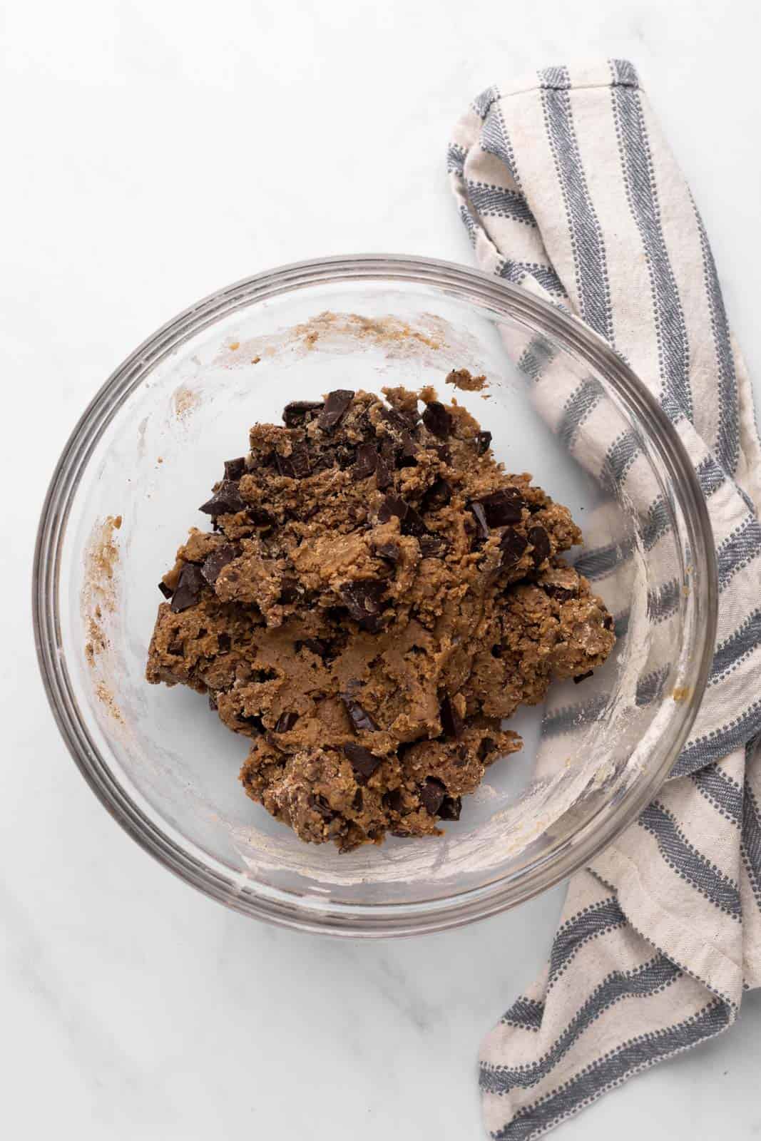 Coffee chocolate chip cookie dough mixed in a glass mixing bowl set on a flat surface.