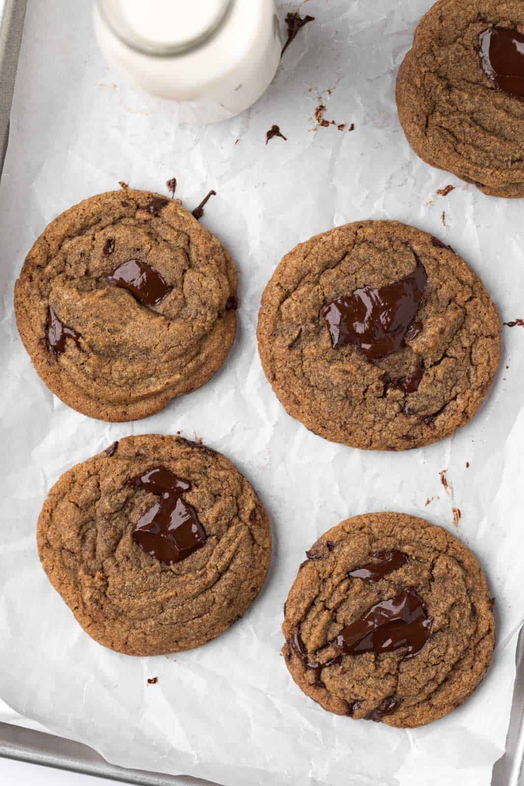 Overhead shot of baked coffee chocolate chip cookies set on a parchment-lined sheet pan.
